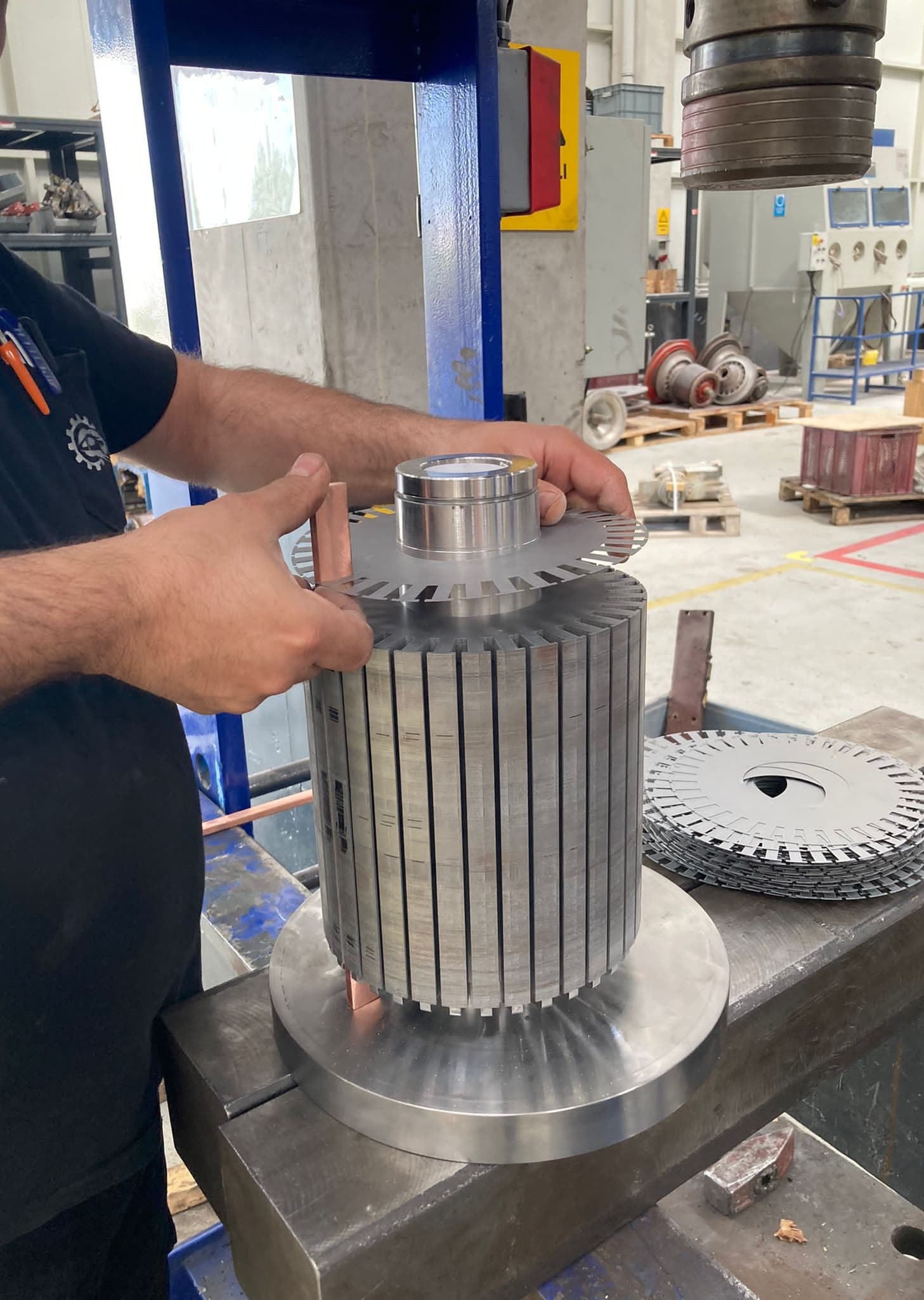 Teknisyenin rotor saclarını mil üzerine dizmesi